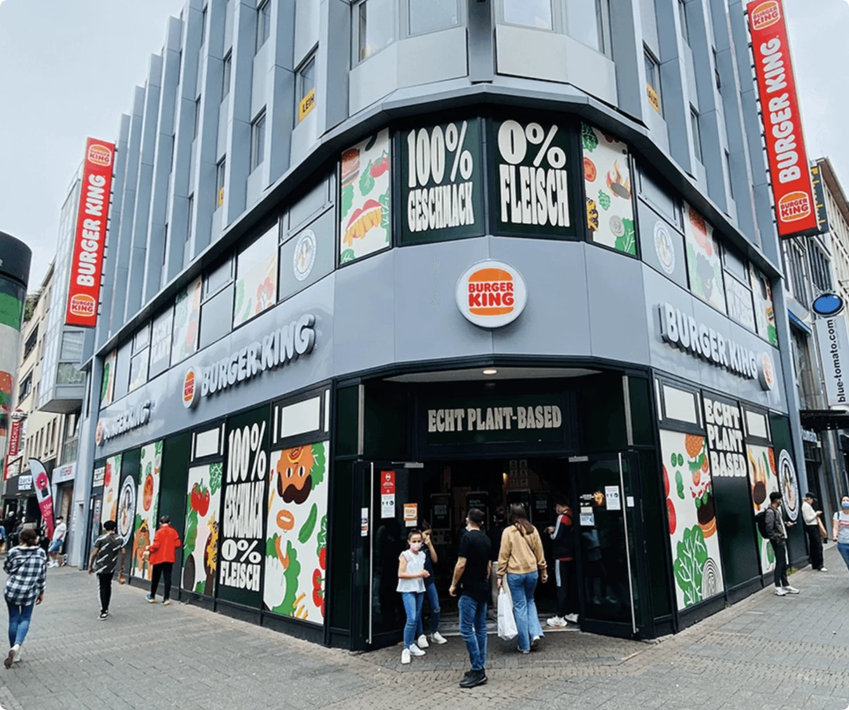 Außenansicht eines vollständig pflanzenbasierten Systemgastronomie-Standorts in Köln mit maßgefertigter Fassadenfolierung von bannerstop