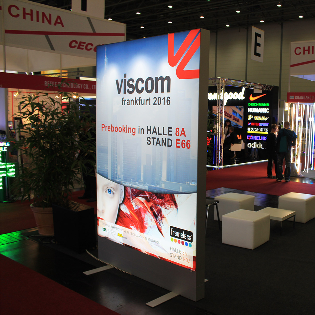 Leuchtender LED-Textilrahmen mit bedrucktem Stoffbanner auf einer Messe.