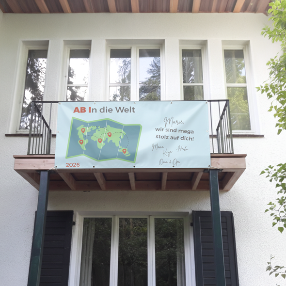 Personalisierter Abibanner am Balkon mit Weltkarten-Design und Grußbotschaft – individuelles Banner für das Abitur 2026.