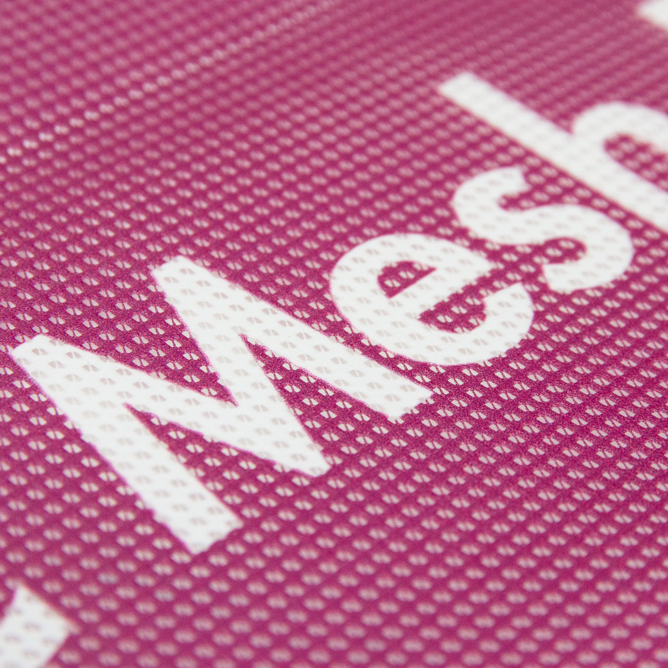 Nahaufnahme eines bedruckten PVC-Mesh-Banners mit deutlich sichtbarer Lochstruktur.