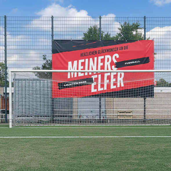 Rotes Stadionbanner am Ballfangzaun eines Fußballplatzes mit großer Werbebotschaft