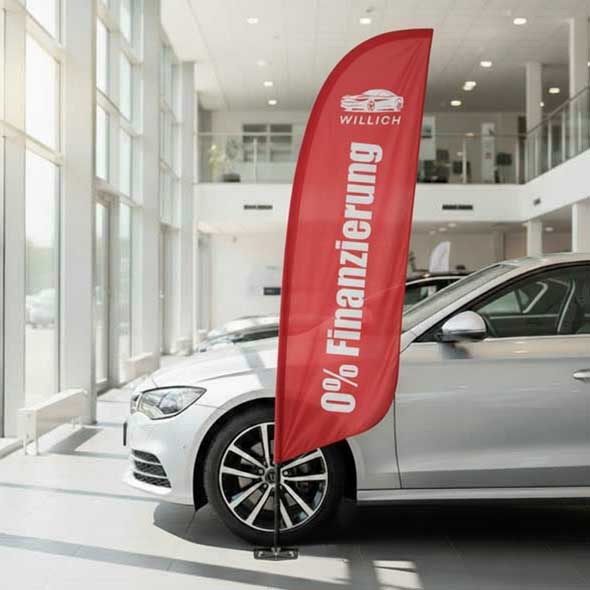 Beachflag mit Werbeaufdruck „0 % Finanzierung“ im Verkaufsraum eines Autohauses – elegante Werbefahne zur Bewerbung von Finanzierungsaktionen direkt am Fahrzeug.