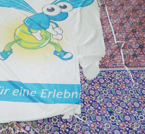 Beschädigte, zerrissene Fahne mit ausgefranstem Saum – Beispiel für Verschleiß durch Wind