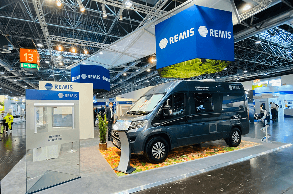 Moderner Messestand mit Fahrzeugpräsentation, großformatigen Hängeelementen und individuell gestalteten Präsentationsflächen, umgesetzt mit Drucklösungen von bannerstop.