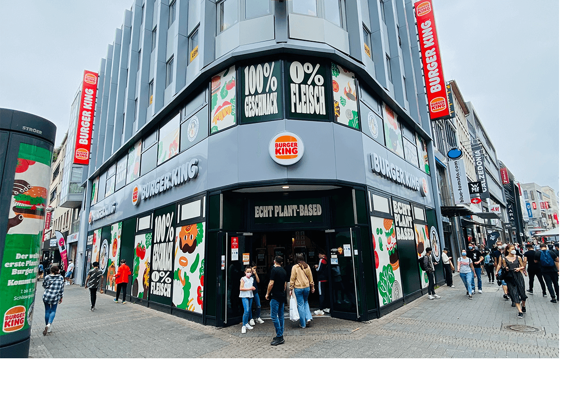 Außenansicht eines vollständig pflanzenbasierten Systemgastronomie-Standorts in Köln mit maßgefertigter Fassadenfolierung von bannerstop.